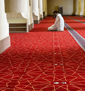 muslim man praying to Allah in a masjid